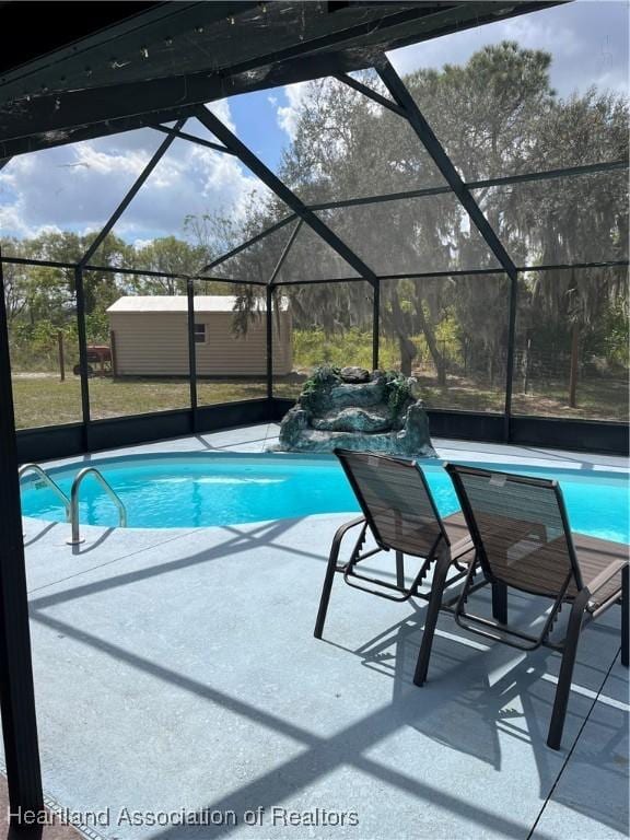 outdoor pool featuring a patio area and glass enclosure