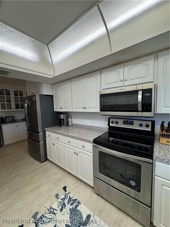 kitchen featuring white cabinets, light wood finished floors, and stainless steel appliances