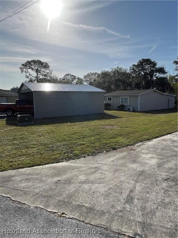 view of side of home featuring an outbuilding and a yard