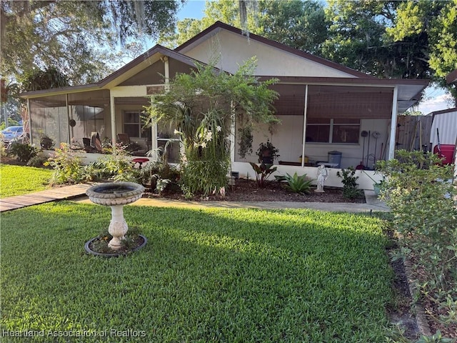 100 Daisy Ln, Lake Placid, FL 33852 - rear view of house with a yard, a sunroom, and stucco siding