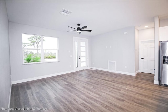 unfurnished living room featuring ceiling fan and dark hardwood / wood-style floors