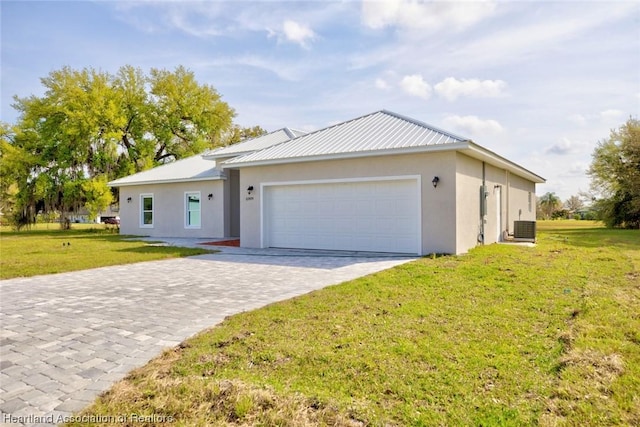 ranch-style house with a garage, central air condition unit, and a front lawn