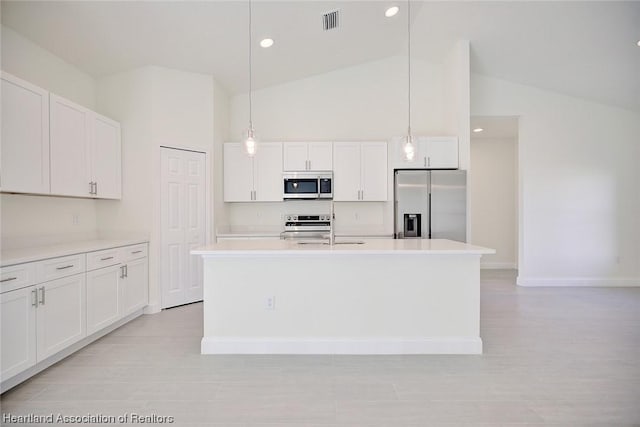 kitchen with white cabinetry, sink, hanging light fixtures, stainless steel appliances, and a center island with sink