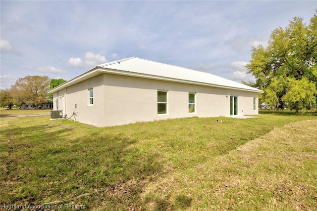 view of side of home featuring a yard and central air condition unit