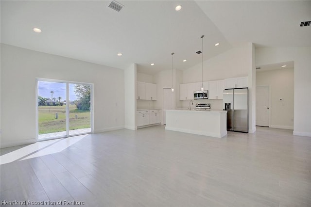 unfurnished living room with sink, high vaulted ceiling, and light hardwood / wood-style flooring