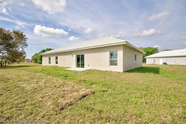 rear view of property featuring a lawn