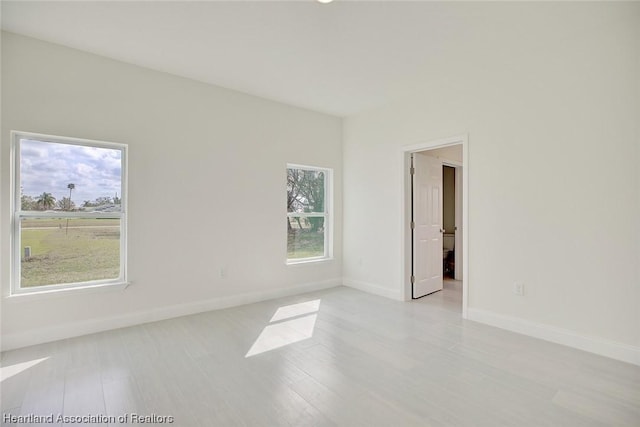 empty room with plenty of natural light and light wood-type flooring