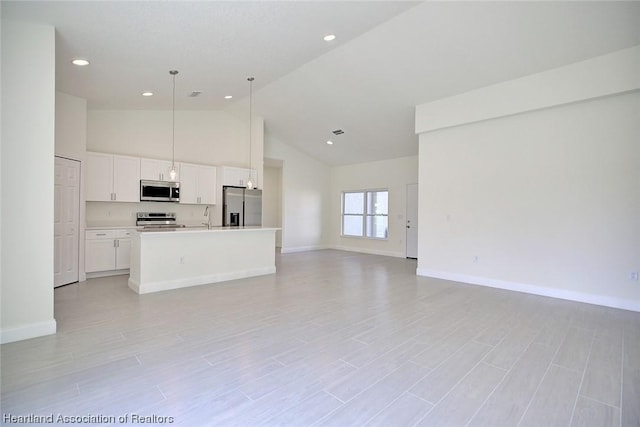 unfurnished living room with sink and high vaulted ceiling