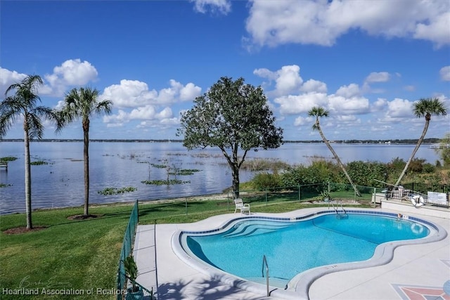 view of pool featuring a water view and a yard