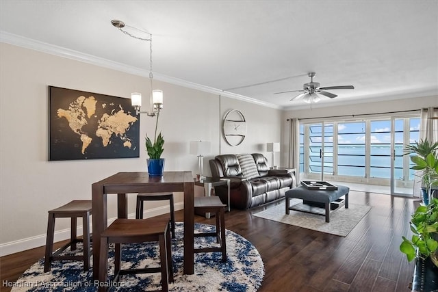 living room with dark wood-type flooring, ceiling fan with notable chandelier, and ornamental molding