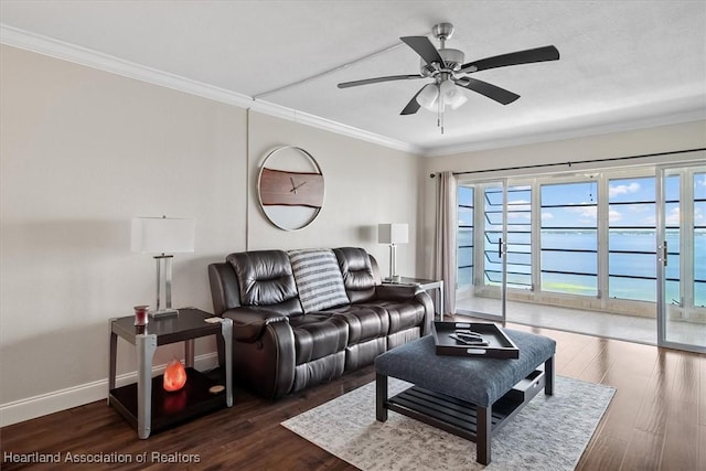 living room featuring dark hardwood / wood-style floors, ceiling fan, ornamental molding, and a water view