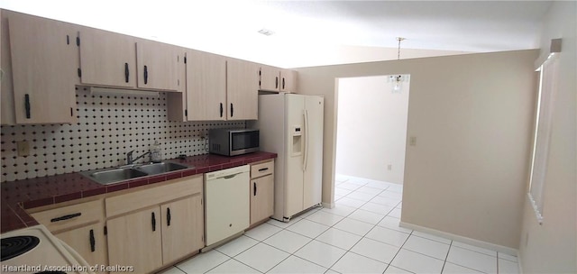 kitchen featuring light brown cabinetry, tasteful backsplash, white appliances, sink, and tile countertops