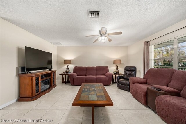 1536 Meadowbrook St, Lake Placid, FL 33852 - living area featuring a ceiling fan, a textured ceiling, light tile patterned floors, and baseboards
