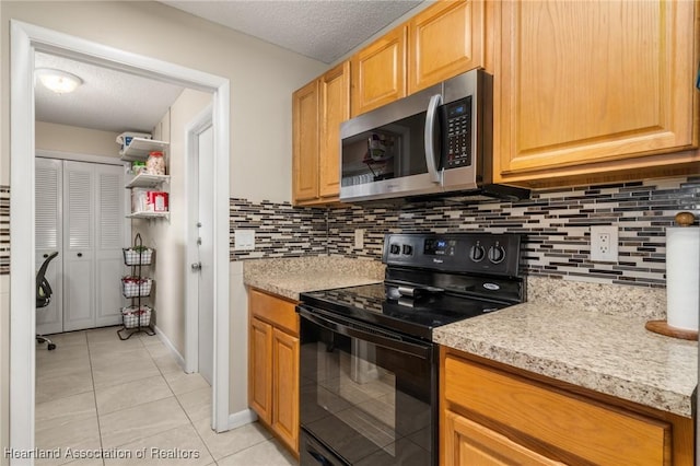 1536 Meadowbrook St, Lake Placid, FL 33852 - kitchen with stainless steel microwave, black / electric stove, light tile patterned floors, backsplash, and a textured ceiling