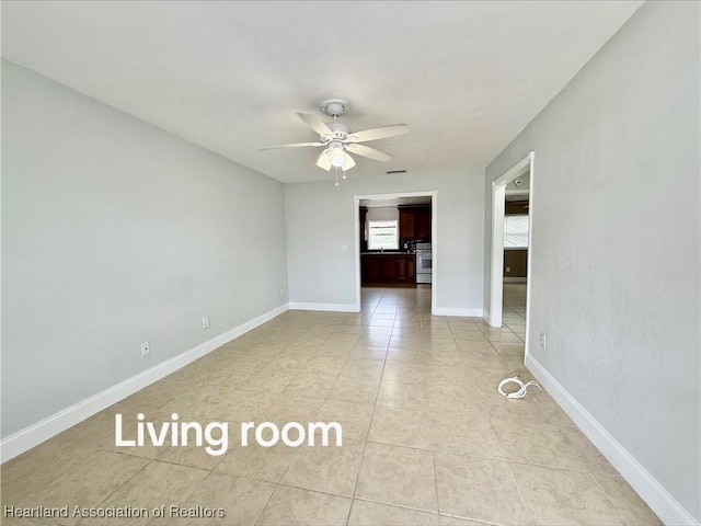 empty room with light tile patterned floors, visible vents, baseboards, and a ceiling fan