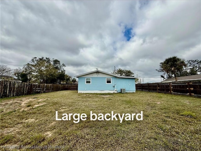 back of house featuring a lawn and a fenced backyard