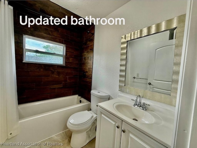 bathroom with a textured wall, toilet, shower / bath combo, vanity, and tile patterned flooring