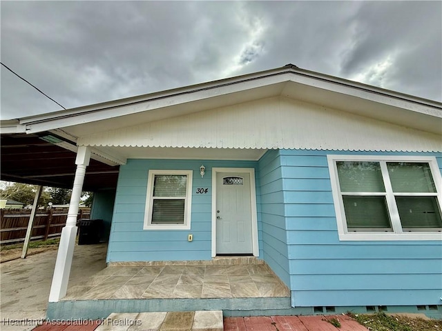 view of front of house featuring fence and a carport