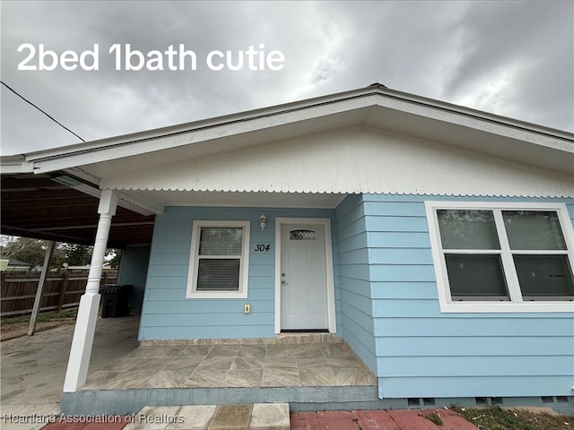 view of front of home with fence and an attached carport