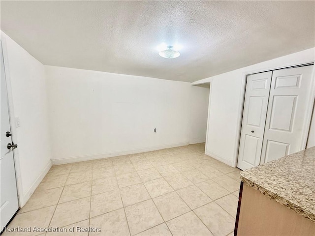 interior space featuring baseboards and a textured ceiling