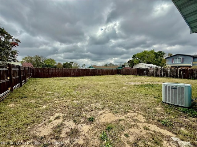 view of yard with central AC and a fenced backyard