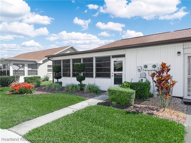 back of property featuring a yard and a sunroom