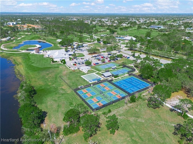 birds eye view of property with golf course view and a water view