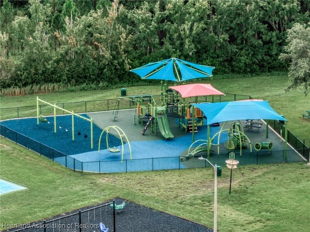 community jungle gym featuring fence and a lawn