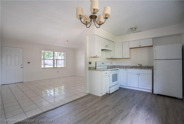 kitchen with a sink, open floor plan, an inviting chandelier, under cabinet range hood, and white appliances