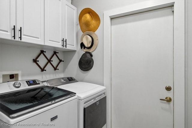 clothes washing area with cabinets and washer and clothes dryer