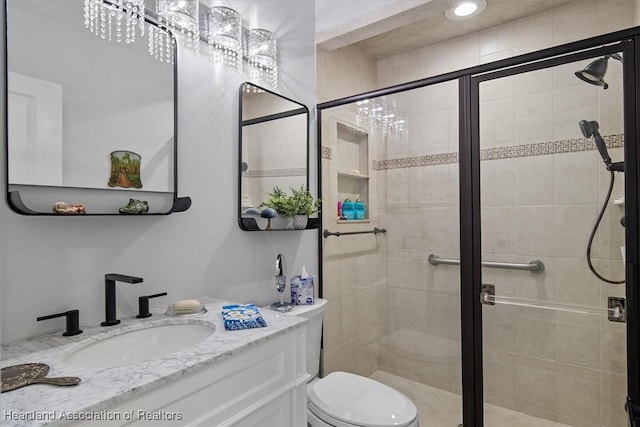 bathroom featuring vanity, toilet, and an enclosed shower