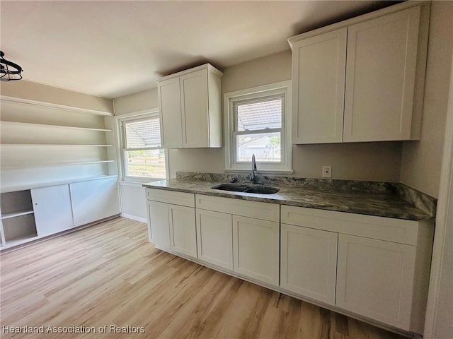 602 Wilhite St, Avon Park, FL 33825 - kitchen with white cabinets, open shelves, a sink, and light wood finished floors