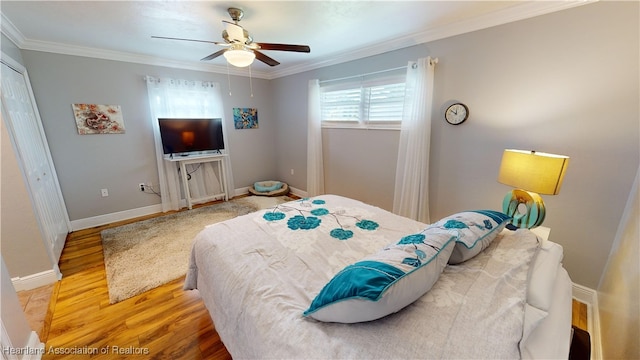 bedroom with wood-type flooring, a closet, ceiling fan, and crown molding