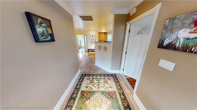 hallway with light tile patterned flooring and ornamental molding