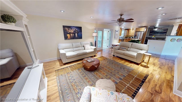 living room with ceiling fan, crown molding, and light wood-type flooring