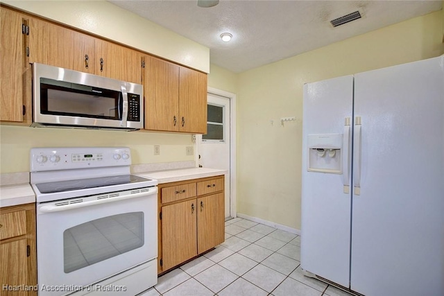 kitchen featuring white appliances and light tile patterned floors