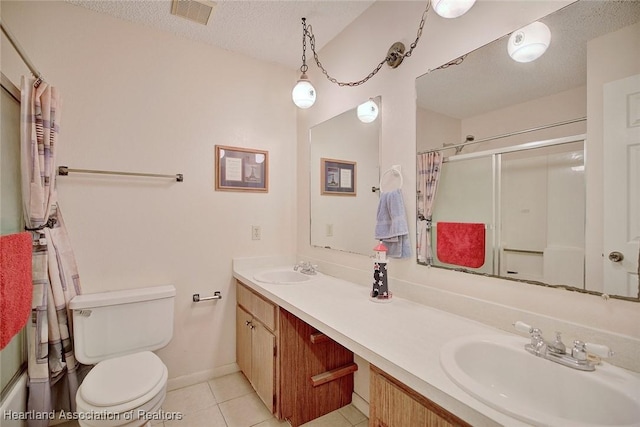 bathroom featuring tile patterned flooring, an enclosed shower, vanity, a textured ceiling, and toilet