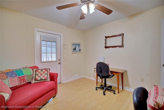 office with ceiling fan, light hardwood / wood-style floors, and a textured ceiling