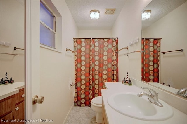 bathroom with vanity, toilet, and a textured ceiling