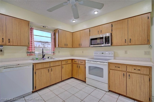 kitchen featuring light tile patterned flooring, white appliances, sink, and a textured ceiling