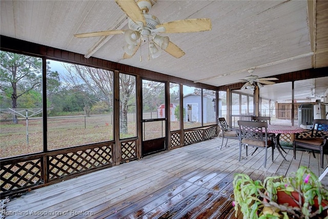 unfurnished sunroom with ceiling fan