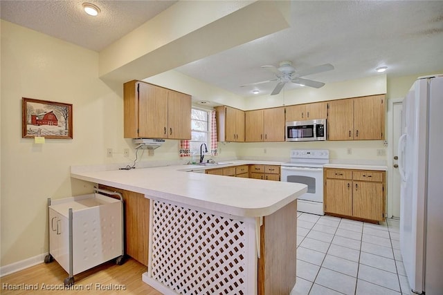 kitchen with sink, white appliances, a textured ceiling, kitchen peninsula, and ceiling fan