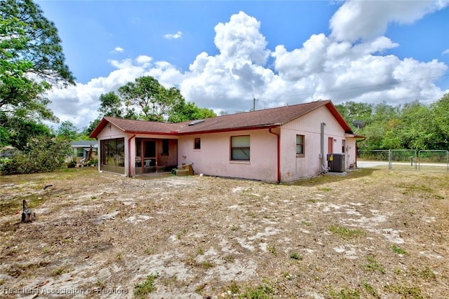 rear view of property with a sunroom, a gate, fence, and cooling unit