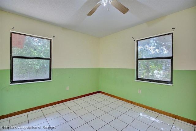 spare room with baseboards, a ceiling fan, and light tile patterned floors