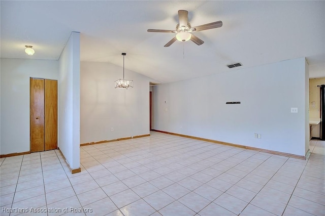 unfurnished room with ceiling fan with notable chandelier, baseboards, vaulted ceiling, and visible vents