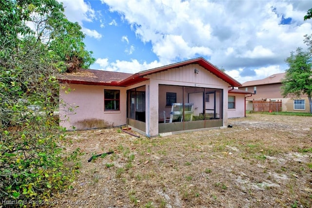 back of property featuring fence and a sunroom