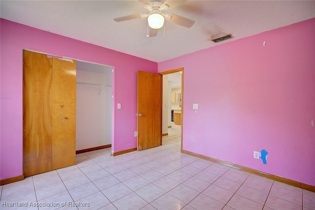 unfurnished bedroom featuring a textured ceiling, baseboards, visible vents, and a closet