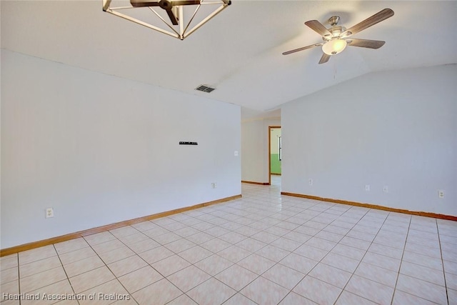 spare room featuring baseboards, ceiling fan, vaulted ceiling, and visible vents