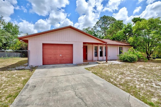 ranch-style home with fence, stucco siding, driveway, and a garage
