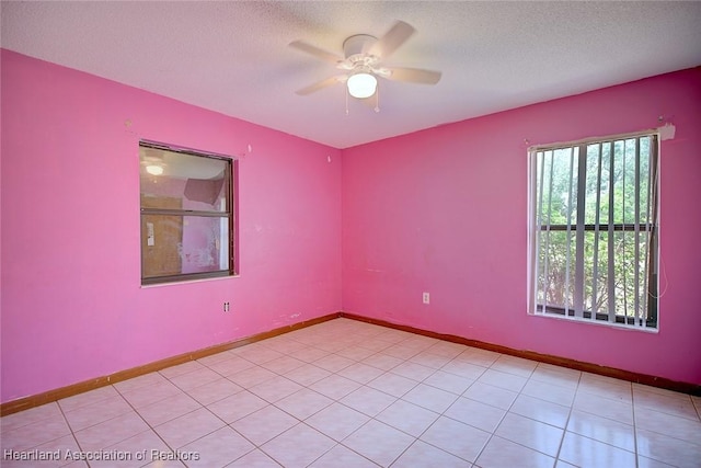 empty room with baseboards, ceiling fan, and a textured ceiling